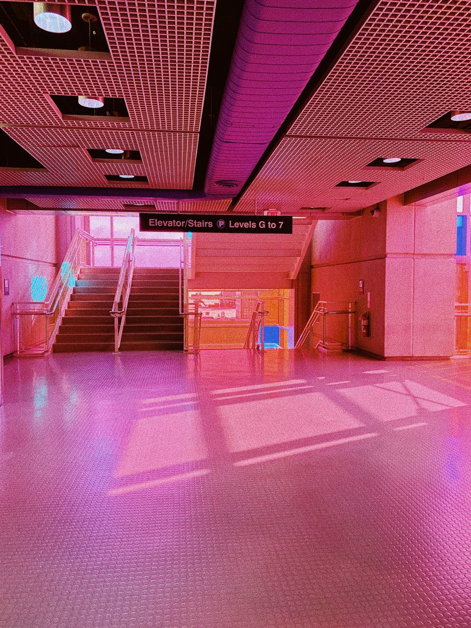 indoors, architecture, illuminated, no people, ceiling, pink color, transportation, lighting equipment, empty, built structure, absence, flooring, purple, modern, communication, reflection, sign, seat, mode of transportation, electric light, parking garage