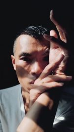 Close-up of young man against black background