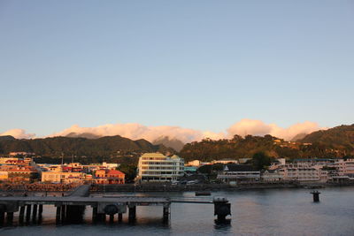 Scenic view of river by buildings against clear sky