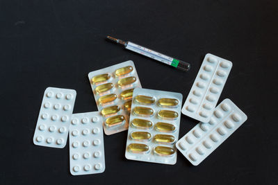 Directly above shot of various medicines on black background