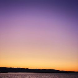 Scenic view of sea against clear sky at sunset