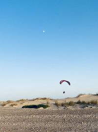 Person paragliding against clear sky