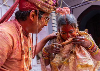 Wet couple enjoying holi while standing outdoors