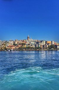 River in front of sea against clear blue sky