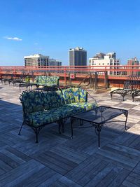 Empty benches on footpath against buildings in city