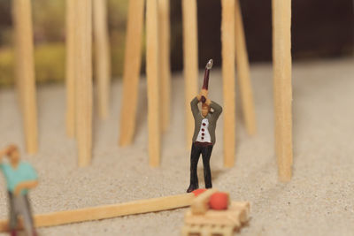 Close-up of figurines with matchsticks on sand