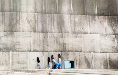 People sitting on concrete wall