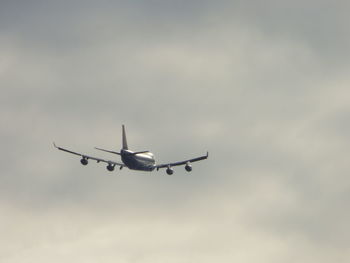 Low angle view of airplane flying against sky