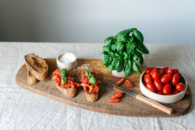 Classic bruschetta with tomatoes on a wooden cutting board.