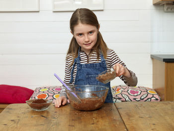 Two girls baking cake in kitchen