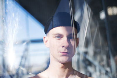 Close-up portrait of young man seen through window