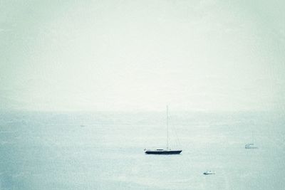 Sailboat sailing on sea against sky