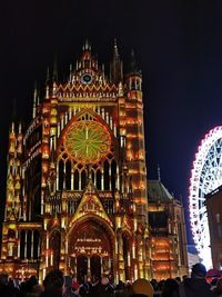 People at amusement park against sky at night