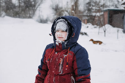 Stop kids from eating snow. outdoor winter portrait of preschooler boy with with a snowy face and