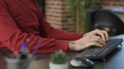 Midsection of woman using computer at home