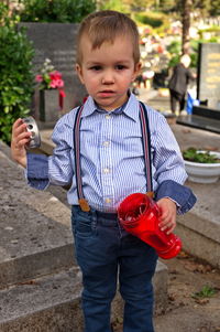 Little toddler holding a candle on the grave