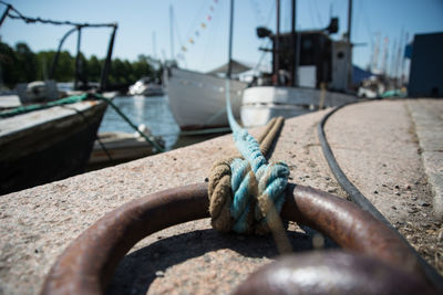 Close-up of rope tied to boat moored at harbor