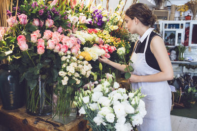 Female florist arranging roses in shop