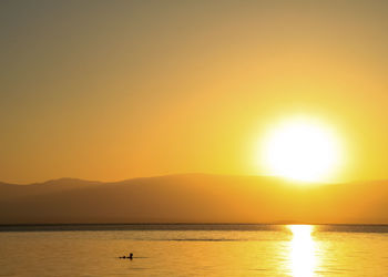 Scenic view of sea against orange sky