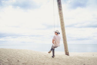 Full length of boy on beach against sky