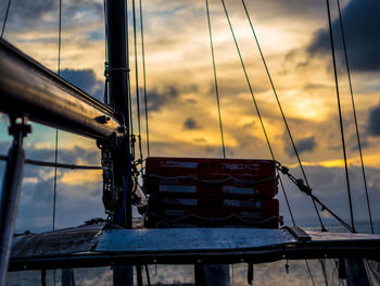 Sailboat moored in sea against sky during sunset