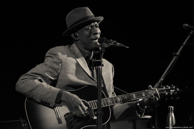 Mid adult man playing guitar at night