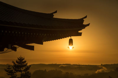 Silhouette temple against sky during sunset