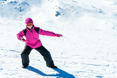Full length portrait of girl standing on snowcapped mountain