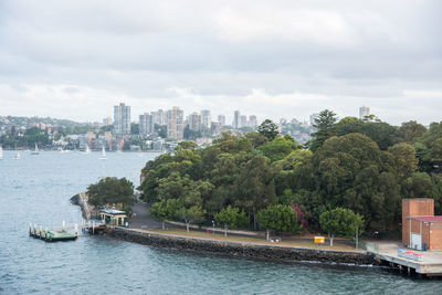 Scenic view of river by buildings against sky