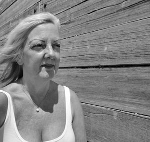 Mature woman looking away by log cabin 