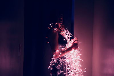 Close-up of hands against illuminated background