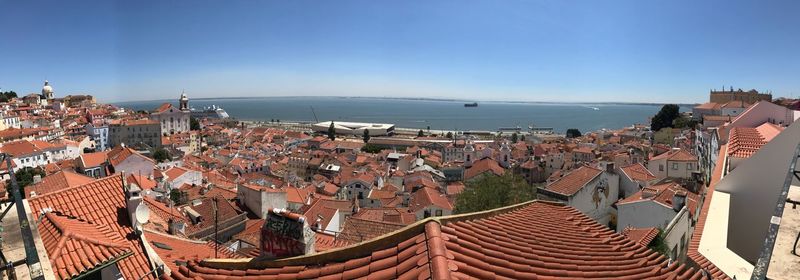 High angle view of town by sea against clear sky