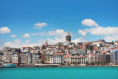 Buildings in city against cloudy sky