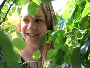 Portrait of a smiling young woman with leaves