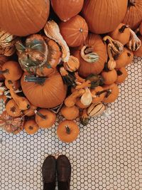 Low section of man standing by pumpkins