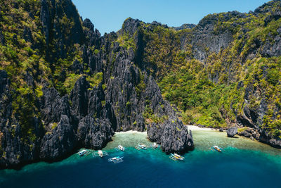 Scenic view of rocks by sea against sky