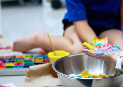 Midsection of people holding multi colored table