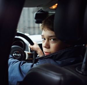 Portrait of teenage boy driving car