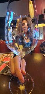 Portrait of woman holding glass at restaurant