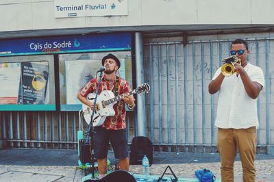 Full length of man playing guitar at music concert