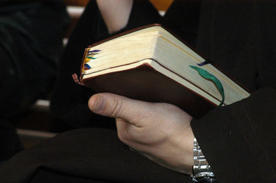 Midsection of person holding book