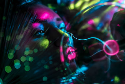 Digital composite image of woman and plasma ball with fiber optics