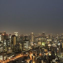 Illuminated cityscape against sky at night