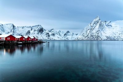 Scenic view of lake by snowcapped mountains against sky