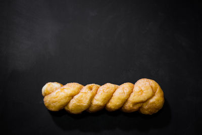 Close-up of bread on table against black background