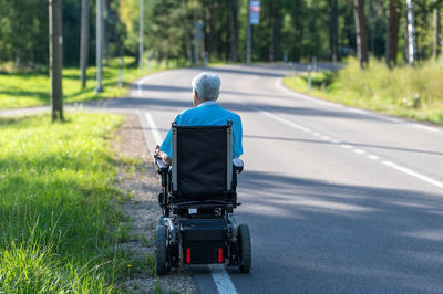 Rear view of man with suitcase on road