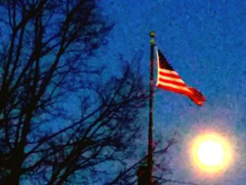 Low angle view of flag against blue sky