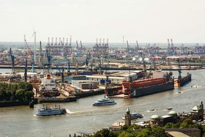 Container ships in sea against clear sky at harbor