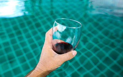 Midsection of man drinking water in swimming pool