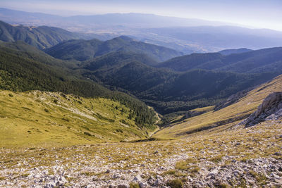 Scenic view of valley and mountains against sky